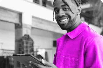 Man smiling at camera with tablet in hand